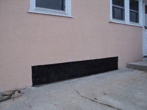 A black metal duct on the side of a building.